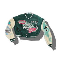 a green and white varsity jacket with patches on it