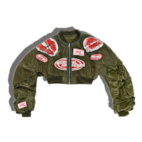 a green bomber jacket with patches on it